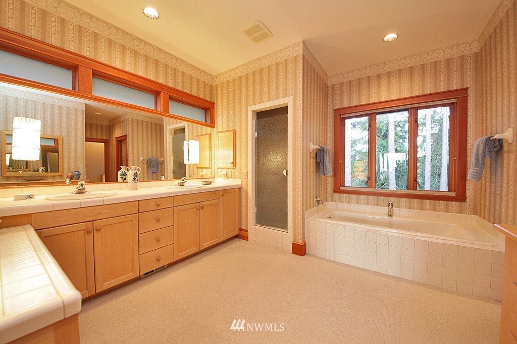 6966 Sills Road Clinton, WA 98236 - Photo 18 of 25 a spacious bathroom with a tub sink and mirror