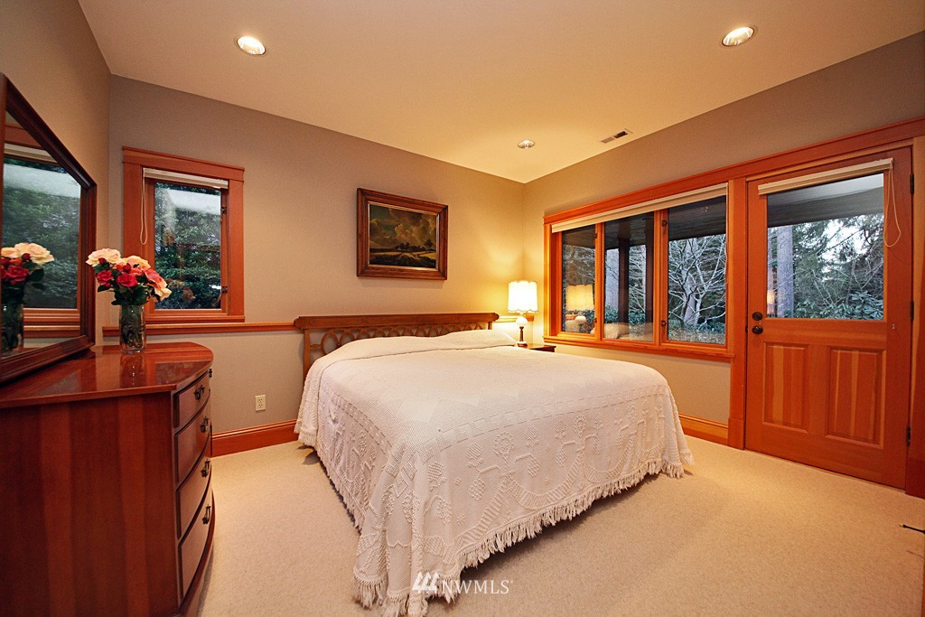 6966 Sills Road Clinton, WA 98236 - Photo 21 of 25 a spacious bedroom with a large bed and a large window