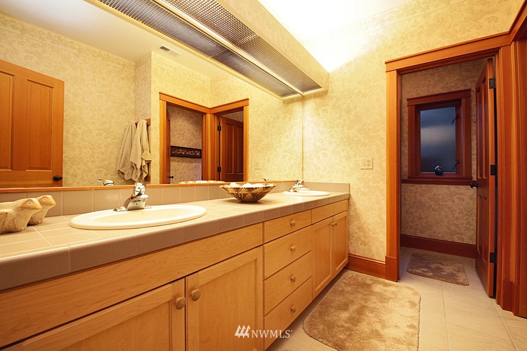 6966 Sills Road Clinton, WA 98236 - Photo 24 of 25 a bathroom with a double vanity sink and a mirror