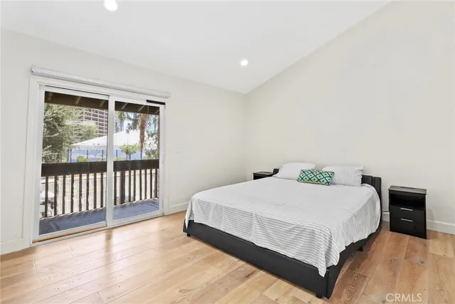 a large bedroom with a bed and wooden floor