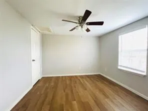 an empty room with a window and a ceiling fan