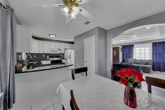 a kitchen with stainless steel appliances kitchen island granite countertop a sink dishwasher and cabinets with wooden floor