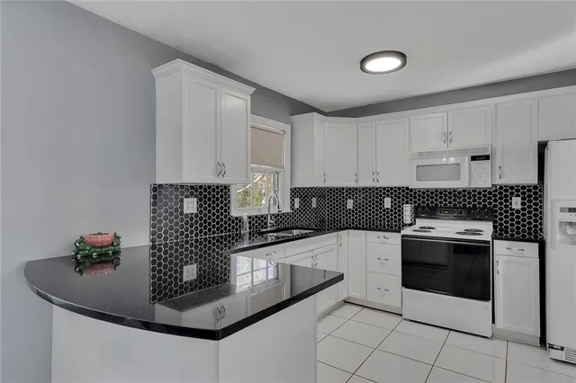 a kitchen with granite countertop a sink stainless steel appliances and cabinets