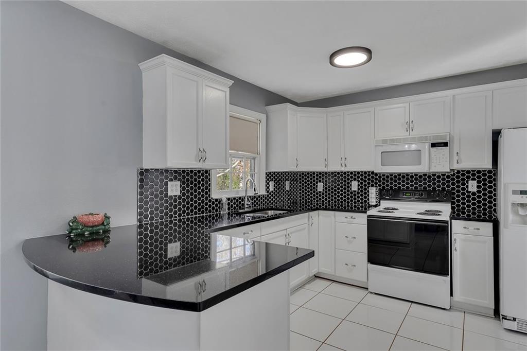 4385 Donegal Circle Lithia Springs, GA 30122 - Photo 12 of 32 a kitchen with granite countertop a sink stainless steel appliances and cabinets
