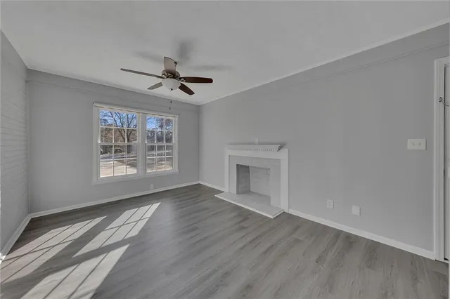 a view of an empty room with a fireplace and a window