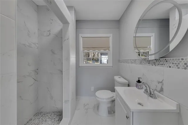 a bathroom with a sink mirror and toilet