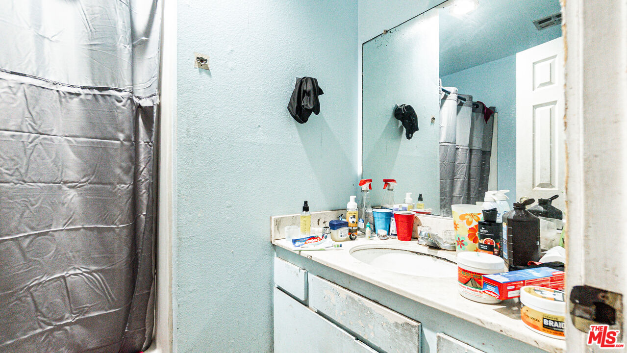 5500 Ackerfield Avenue, Unit 104 Long Beach, CA 90805 - Photo 11 of 19 a bathroom with a sink vanity and a mirror