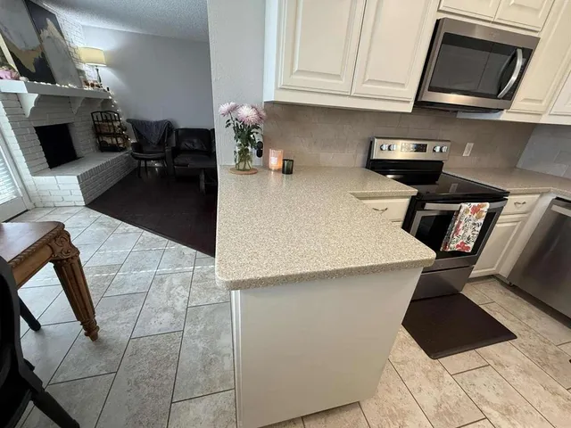 a kitchen with stainless steel appliances granite countertop a sink stove and microwave