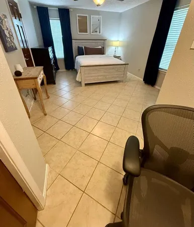 a bedroom with a bed lamp and window