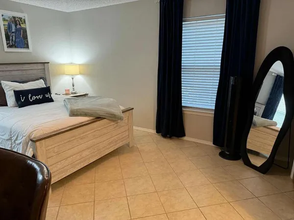 a bedroom with a bed and a mirror on dresser