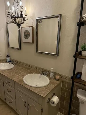 a bathroom with a granite countertop sink toilet and mirror