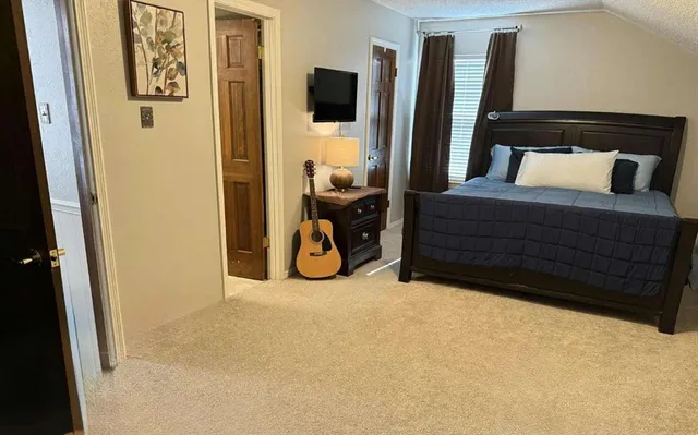 a bedroom with a bed a flat screen tv and a couch