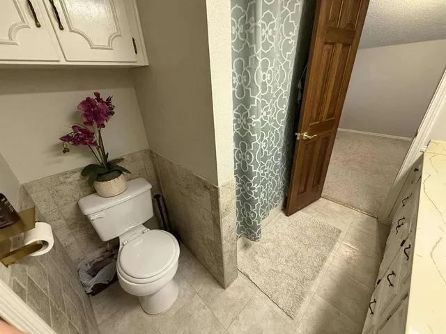 a view of house with outdoor seating and covered with wooden fence