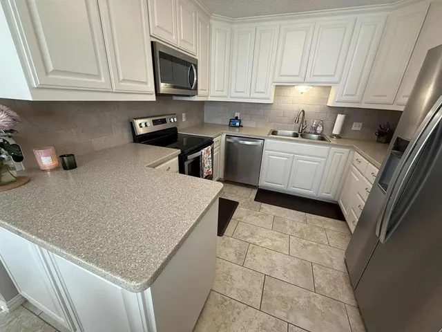 a kitchen with a sink cabinets and appliances
