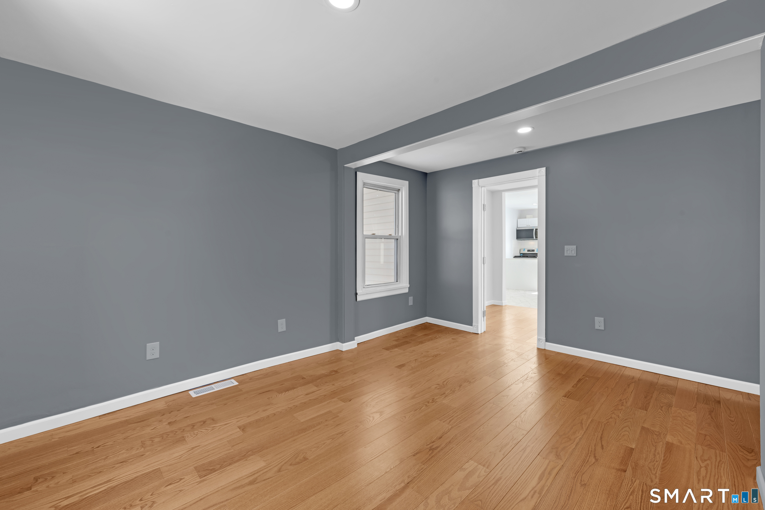 254 Broad Street Norwich, CT 06360 - Photo 13 of 38 a view of an empty room with window and wooden floor