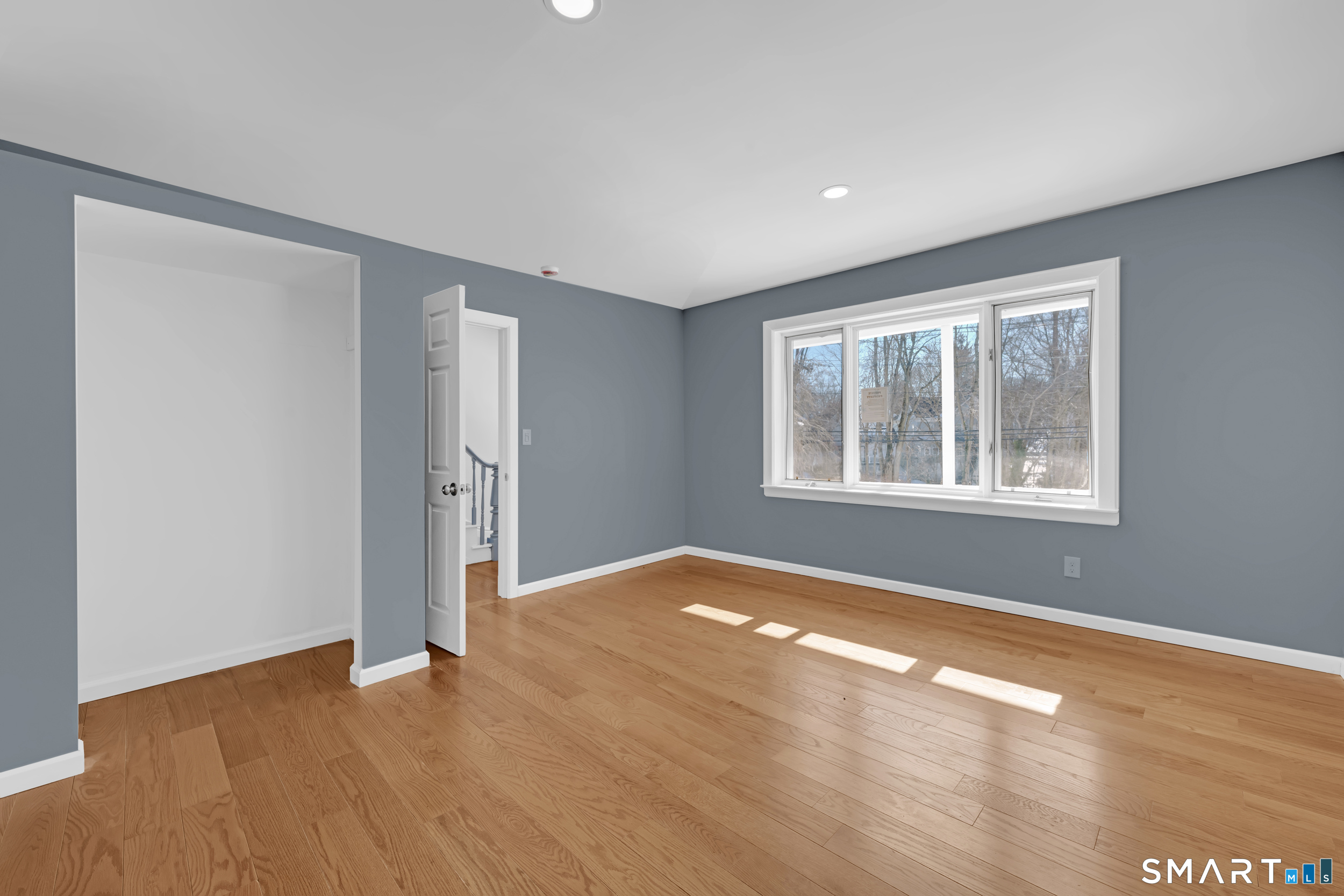 254 Broad Street Norwich, CT 06360 - Photo 16 of 38 a view of an empty room with window and wooden floor