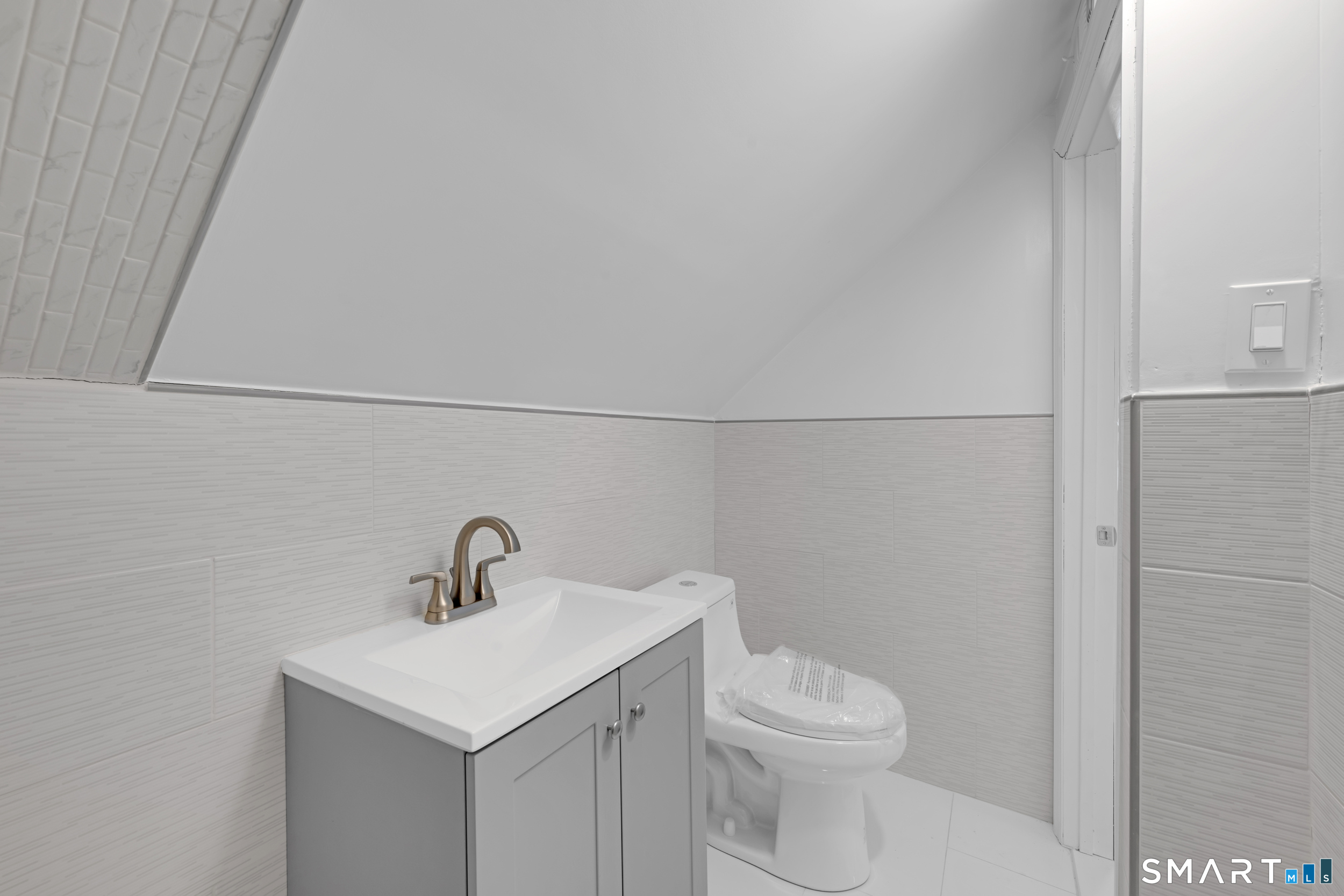 254 Broad Street Norwich, CT 06360 - Photo 26 of 38 a bathroom with a toilet sink and mirror