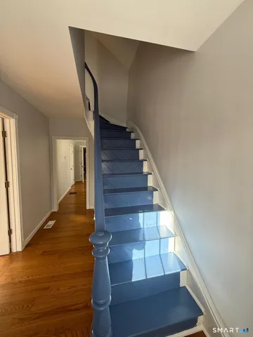 a view of entryway and hall with wooden floor