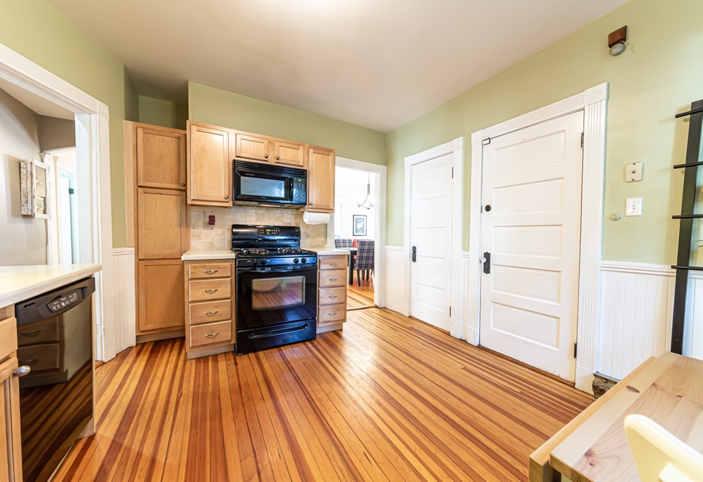 16 Parkton Road, Unit A Boston, MA 02130 - Photo 14 of 31 a kitchen with wooden floors and wooden cabinets