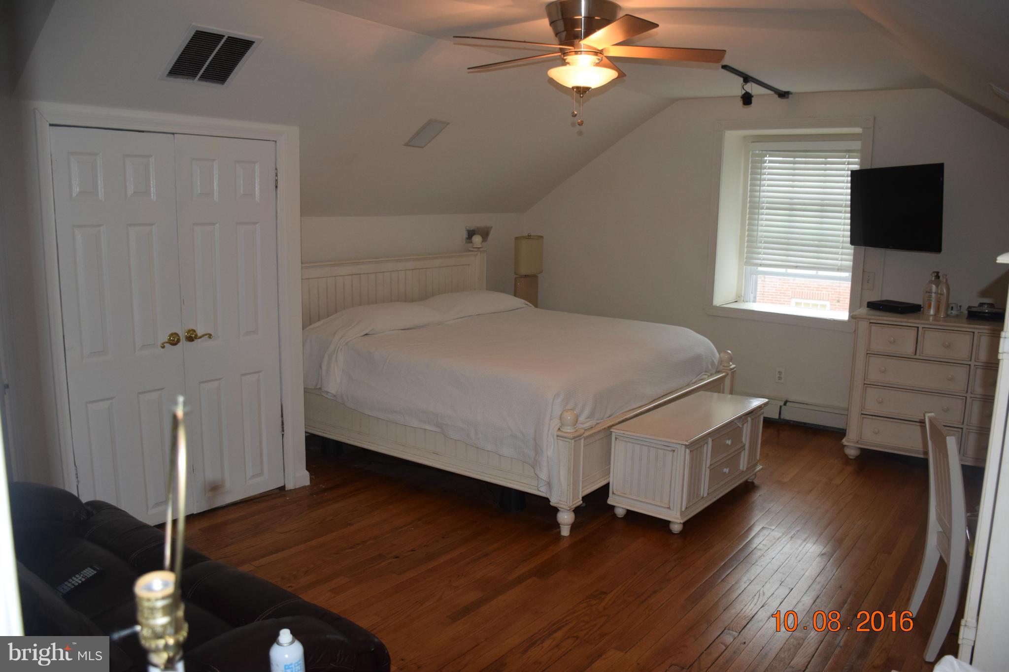 6810 Campfield Road Baltimore, MD 21207 - Photo 16 of 30 a bedroom with a bed and wooden floor