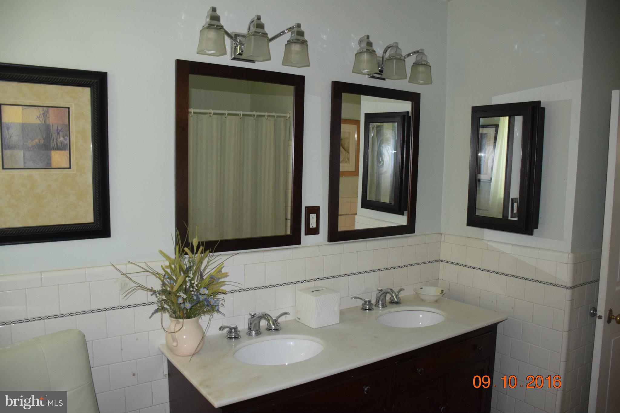 6810 Campfield Road Baltimore, MD 21207 - Photo 18 of 30 a bathroom with 2 sink and a mirror