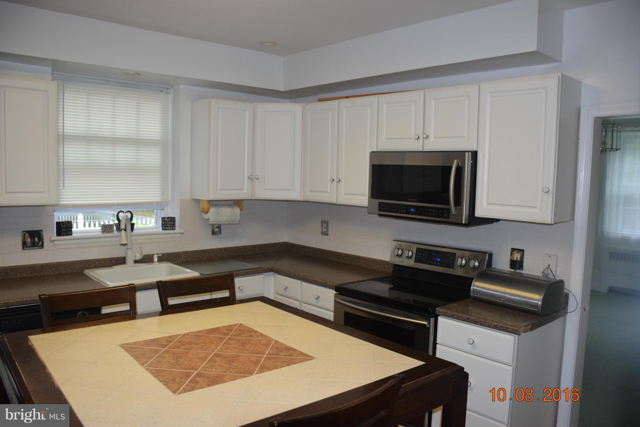 6810 Campfield Road Baltimore, MD 21207 - Photo 8 of 30 a kitchen with a stove a sink and a microwave