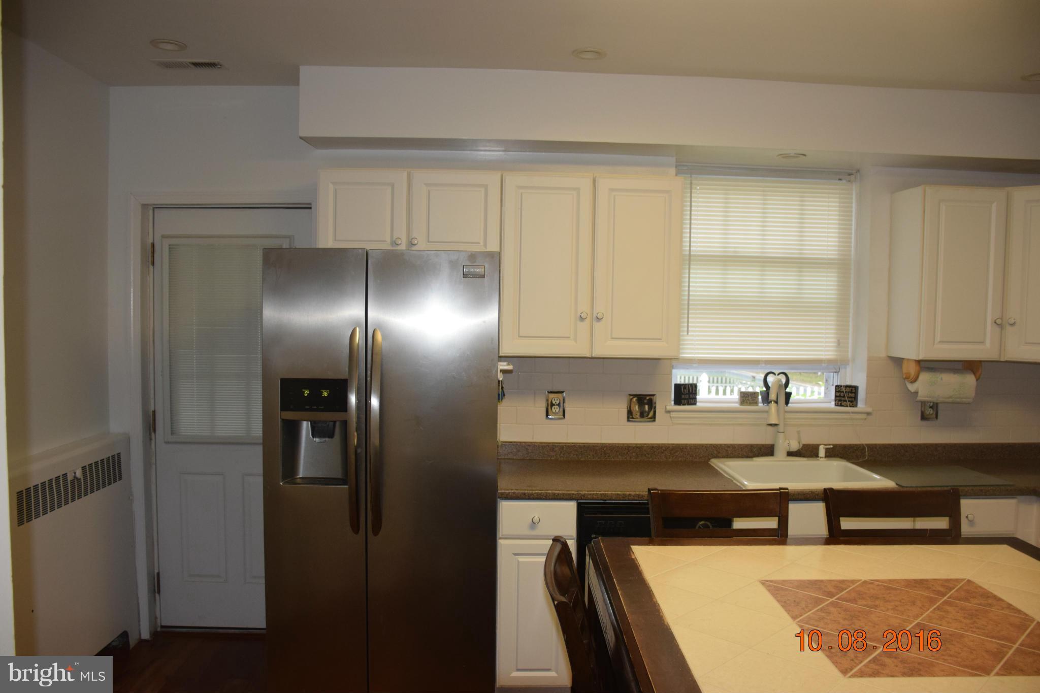 6810 Campfield Road Baltimore, MD 21207 - Photo 9 of 30 a kitchen with stainless steel appliances a sink stove and cabinets