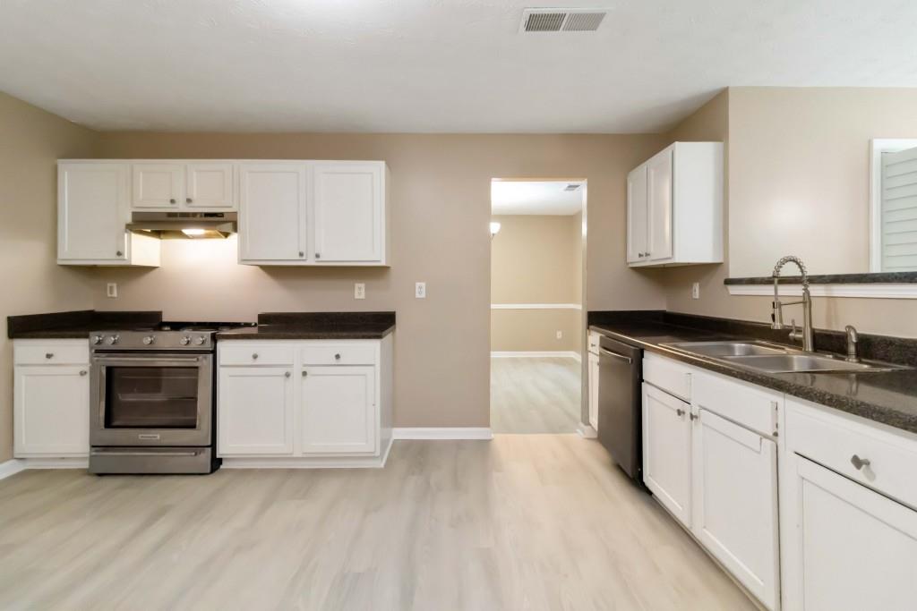 4783 Creekside Place Decatur, GA 30035 - Photo 7 of 24 a kitchen with granite countertop white cabinets and white appliances