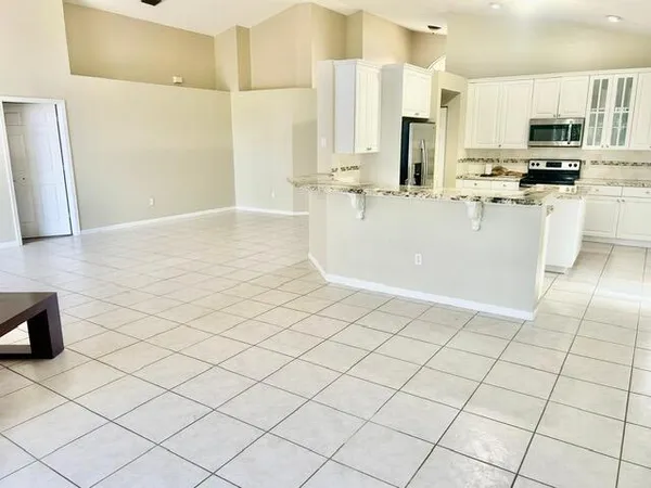 a kitchen with kitchen island granite countertop a stove sink and microwave