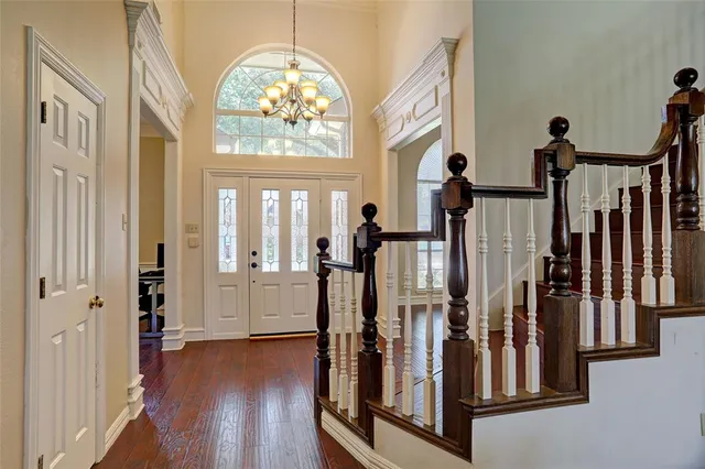 a view of a hallway with entryway wooden floor and stairs