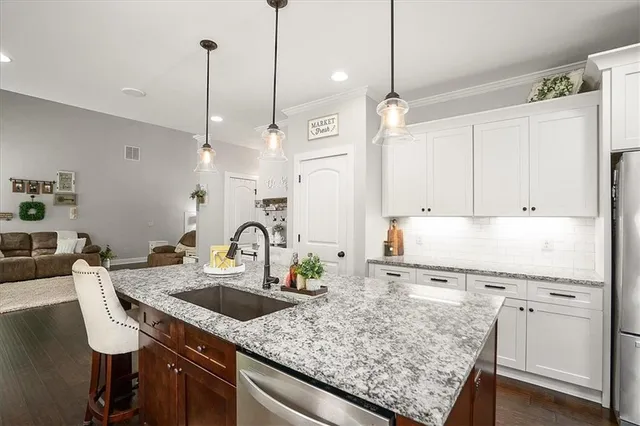 a kitchen with granite countertop a sink a counter space appliances and cabinets