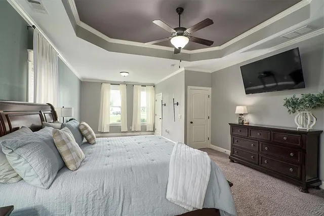 a spacious bedroom with a large bed and a flat tv screen on dresser