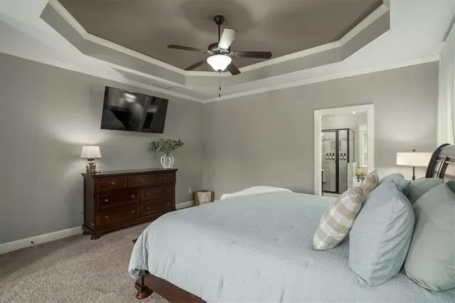 a bedroom with a bed a flat screen tv and a chandelier