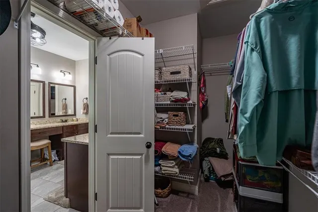 a view of walk in closet with clothes and shoes