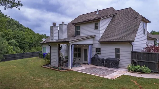a view of a house with a big yard and a large tree