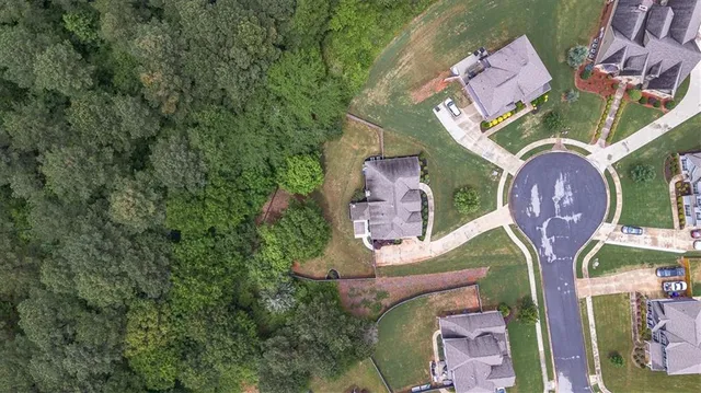 an aerial view of a house with garden space and a swimming pool