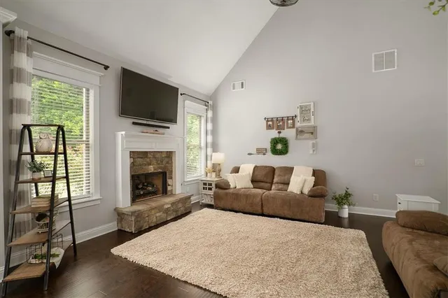 a living room with furniture a flat screen tv and a fireplace