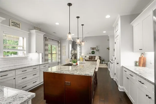 a large kitchen with granite countertop a large counter top appliances a sink and a window