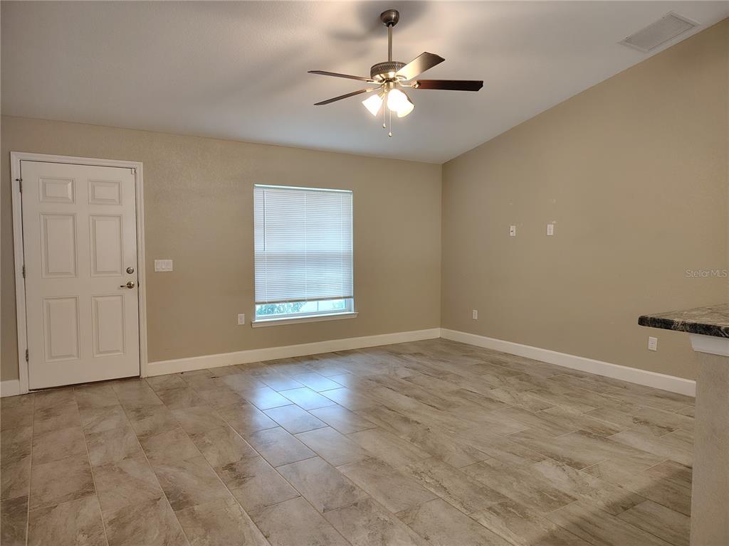 13093 Southwest 35th Circle Ocala, FL 34473 - Photo 3 of 15 an empty room with windows and fan