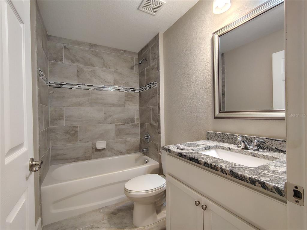 13093 Southwest 35th Circle Ocala, FL 34473 - Photo 8 of 15 a bathroom with a granite countertop sink a toilet and shower