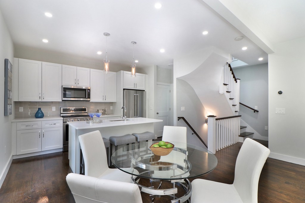 59 Mozart Street, Unit 2 Boston, MA 02130 - Photo 1 of 21 a kitchen with stainless steel appliances kitchen island granite countertop a refrigerator a stove a sink a dining table and chairs with wooden floor