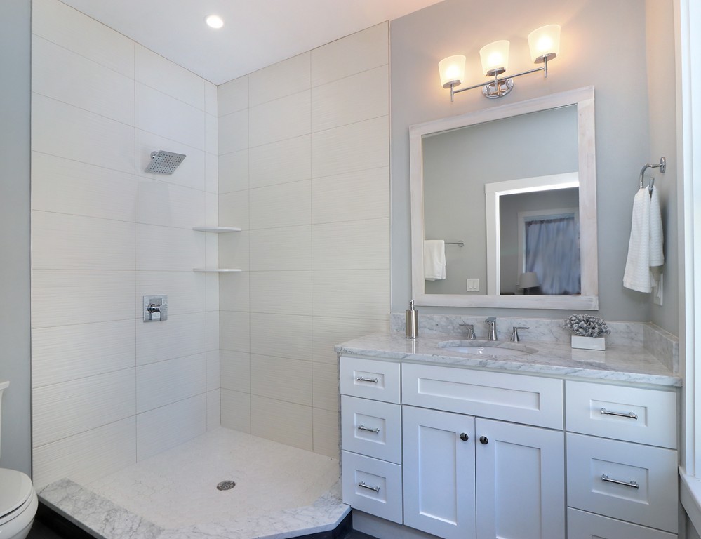 59 Mozart Street, Unit 2 Boston, MA 02130 - Photo 17 of 21 a bathroom with a granite countertop sink a mirror and a bathtub
