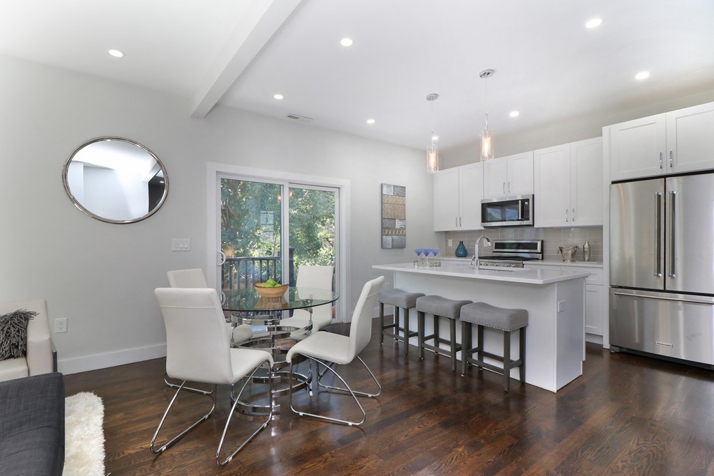 59 Mozart Street, Unit 2 Boston, MA 02130 - Photo 2 of 21 a kitchen with stainless steel appliances granite countertop a stove a refrigerator a kitchen island with a dining table and chairs