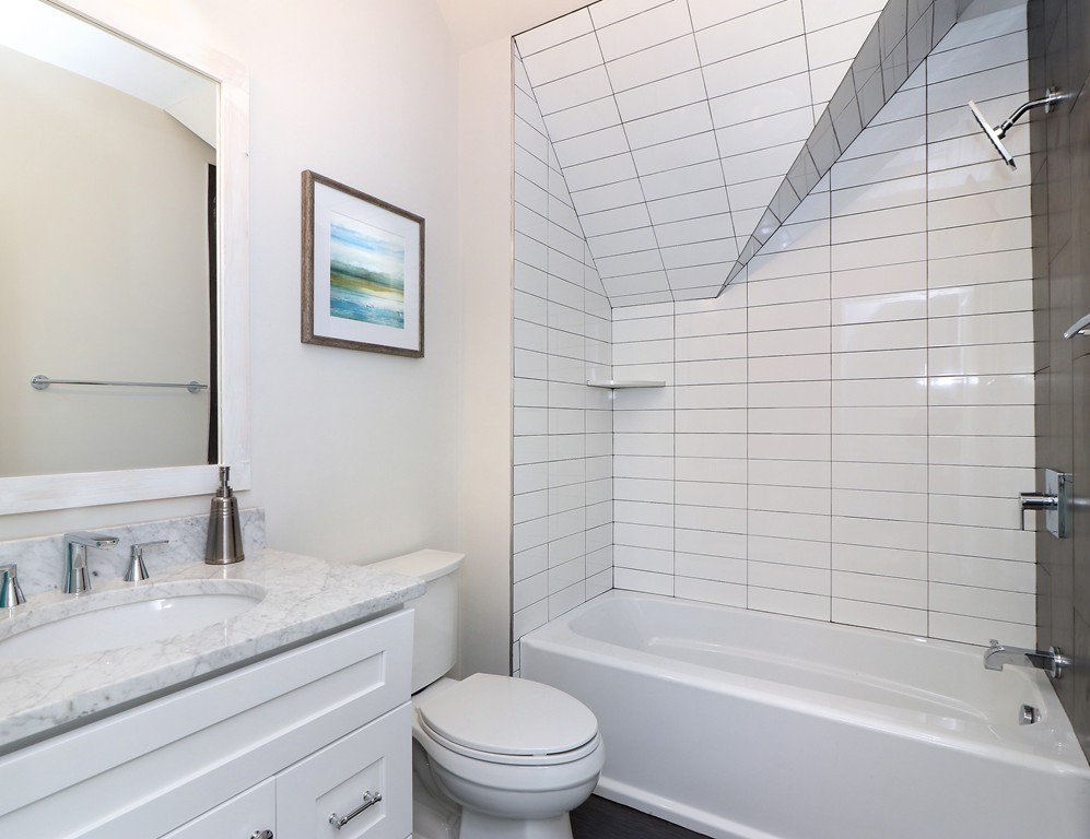 59 Mozart Street, Unit 2 Boston, MA 02130 - Photo 6 of 21 a bathroom with a granite countertop sink a toilet and bathtub