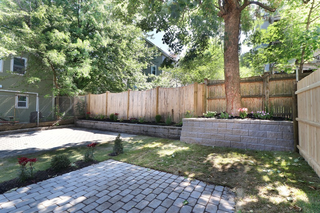 59 Mozart Street, Unit 2 Boston, MA 02130 - Photo 9 of 21 a view of a backyard with a large tree and a garden