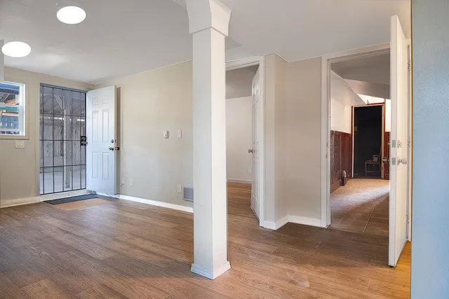an empty room with wooden floor and windows