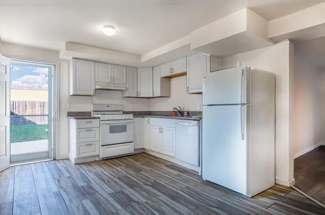 a kitchen with white cabinets and white appliances