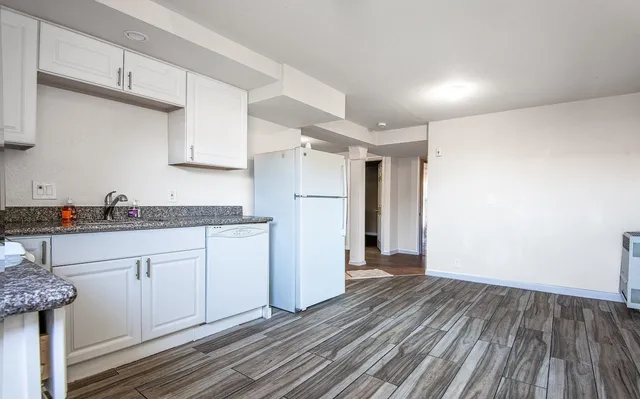 a kitchen with a refrigerator and white cabinets
