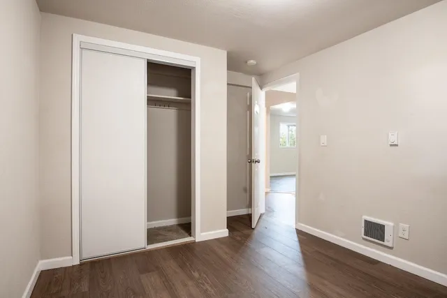 a view of an empty room with wooden floor
