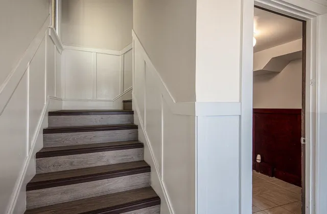 a view of staircase with white walls and white door